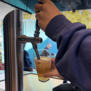 Eine Hand zapft Bier